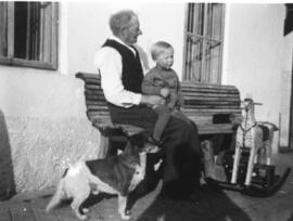 Alter Mann mit Kind auf Hausbank in Ebbs